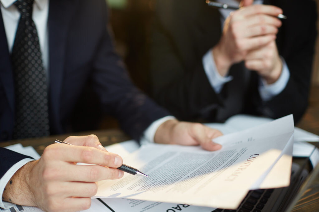 Closeup shot of unrecognizable businessman reading contract documentation at meeting with financial partner